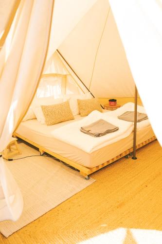 a bed in a tent in a room at Tente Glamping sans vis à vis, nature & calme, côte Vicentine in Rogil