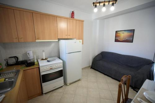 a small kitchen with a refrigerator and a bed at Blue Dreams Astros in Paralio Astros