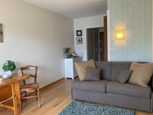 un salon avec un canapé et une table dans l'établissement Studio Terrasse Vue Mer, à La Baule