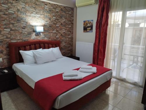 a bedroom with a bed with towels on it at Hotel Villa Pigasos in Paralia Katerinis