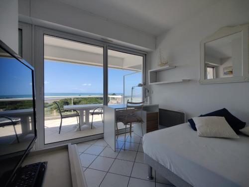 une chambre avec un lit et un balcon avec une table dans l'établissement Côté Océan, Vue Mer et Terrasse, à La Rochelle