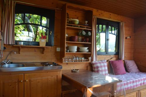 - une cuisine avec un canapé, un évier et 2 fenêtres dans l'établissement Nid douillet en Ardèche, à Chomérac
