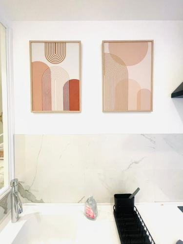 une cuisine avec 2 photos sur le mur et un évier dans l'établissement Le Churchill nouveauté 2024 H&F, à Dinard