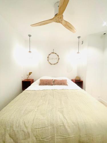 une chambre avec un grand lit avec un ventilateur de plafond dans l'établissement Le Churchill nouveauté 2024 H&F, à Dinard