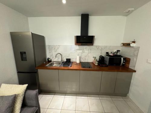 Il comprend une cuisine équipée d'un évier et d'un comptoir avec un four micro-ondes. dans l'établissement Jolie deux pièces au cœur de Nice, à Nice