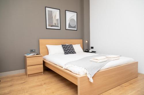 a bedroom with a bed with a wooden headboard at SEKLER Apartments in Cluj-Napoca