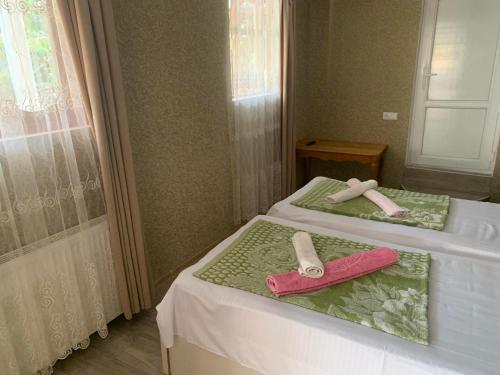 two beds in a room with towels on them at Tsivi Tba in Tskaltubo