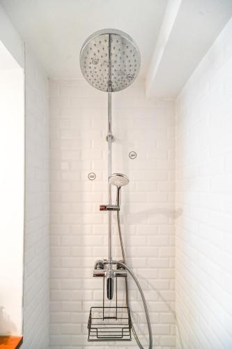 une douche dans une salle de bain avec une pomme de douche dans l'établissement L'Atelier de la Madeleine - Dax, à Dax