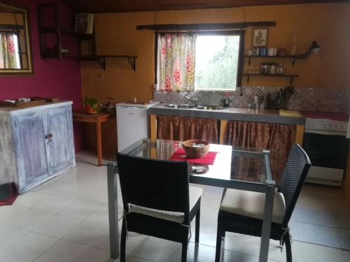 a kitchen with a glass table and chairs in it at Espacio acogedor en la montaña in Sant Jaume de Llierca