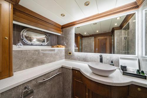 a bathroom with a sink and a large mirror at iRama Luxury Superyacht 6 Cabins & Hot Tub & Water Toys in Cannes