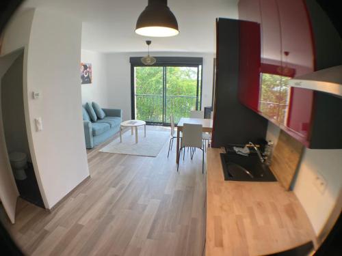 Il comprend un salon et une cuisine avec une table et un canapé. dans l'établissement Superbe appartement avec vue sur la tour Eiffel, à Saint-Leu-la-Forêt