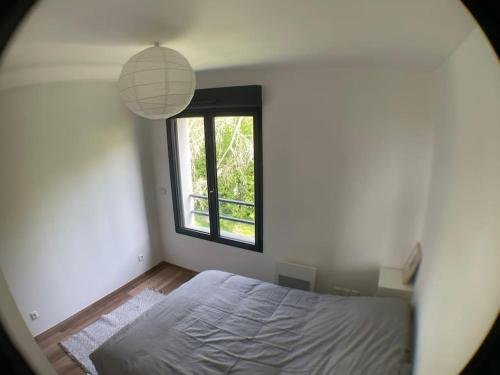 une chambre avec un grand lit et une fenêtre dans l'établissement Superbe appartement avec vue sur la tour Eiffel, à Saint-Leu-la-Forêt