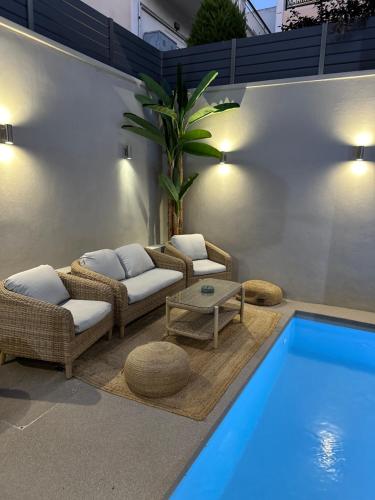 a swimming pool with couches and chairs next to a swimming pool at ILION Villa in Athens