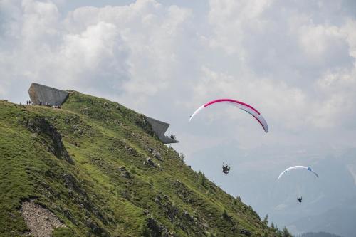 a group of people flying kites on a hill at Hotel Elisabeth in Chienes
