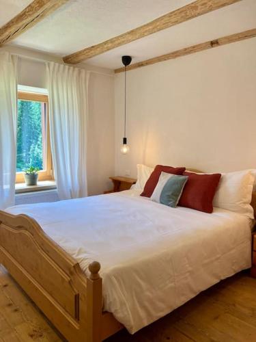 a bedroom with a large white bed with red pillows at Stella Alpina - Romantic getaway in Falcade