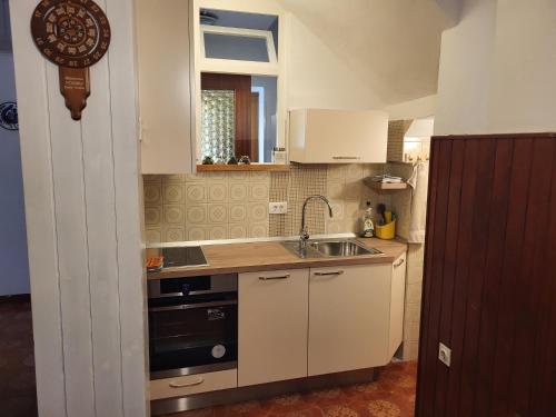a small kitchen with a sink and a stove at Sobe pri Anici in Koper