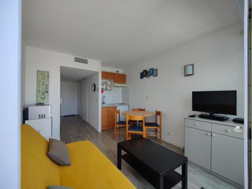 un salon avec un canapé jaune et une cuisine dans l'établissement L'Albatros- Parking - Piscine, à La Rochelle