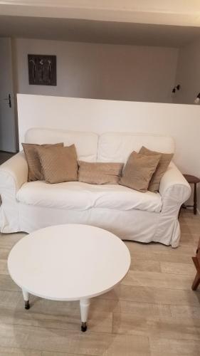 a living room with a white couch and a table at STUDIO indépendant, proche hôpitaux Est in Lyon