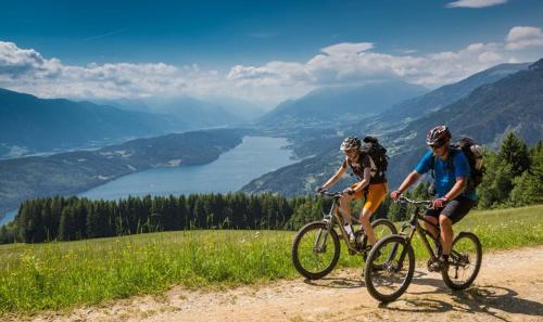 two people riding bikes on a dirt road overlooking a valley at Exklusives STALL-LOFT "ZUM PULVERER" - Naturdesign hinter historischen Mauern - AusZeit für 2 inmitten des Isarwinkels in Gaißach