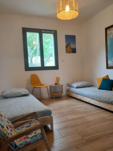 une chambre avec deux lits et une chaise dedans dans l'établissement Maison moderne avec jardin et jacuzzi, à La Bouilladisse