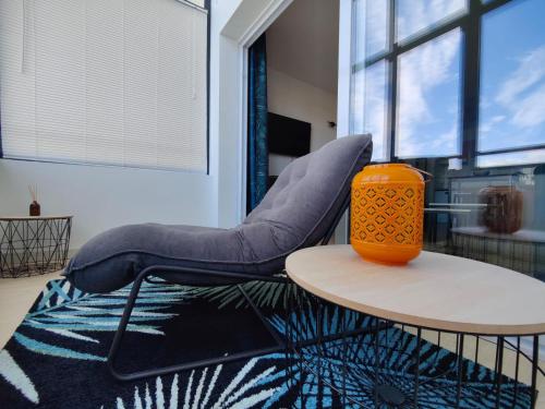 une chaise posée sur un tapis à côté d'une table dans l'établissement L'Escapade 1 chambre-parking-piscine, à La Rochelle