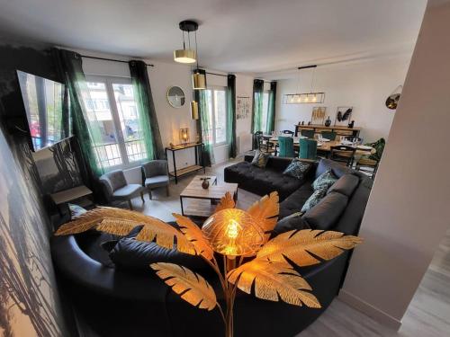 a living room with a black couch and a table at L'Antre des Généraux in Percy