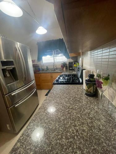 a kitchen with a stainless steel refrigerator and a counter top at Apartamento completo con jacuzzi y gazebo in Santo Domingo