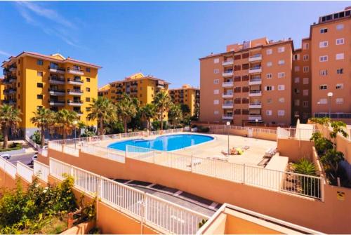 a swimming pool in the middle of some buildings at Ocean Sky in Candelaria