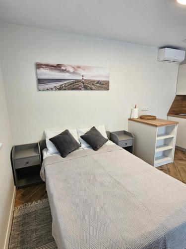 een slaapkamer met een groot bed met twee kussens bij Apartmens LORETA in Šventoji