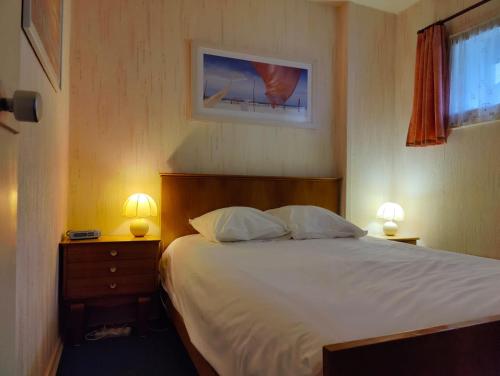 une chambre avec un grand lit avec deux lampes dans l'établissement Vue mer et parking, à La Rochelle