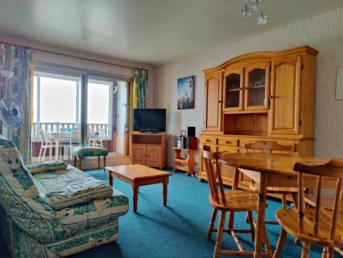 un salon avec une table et un canapé dans l'établissement Vue mer et parking, à La Rochelle