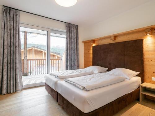 ein Schlafzimmer mit zwei Betten und einem großen Fenster in der Unterkunft Apart33 Top 1-26 in Haus im Ennstal