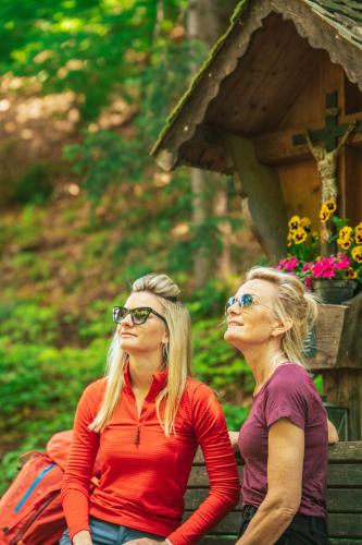 two women standing next to each other in front of a house at Hotel Elisabeth in Chienes