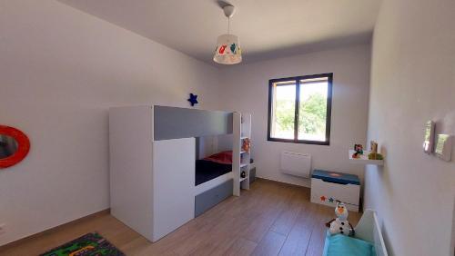 une chambre d'enfant avec un lit blanc et une fenêtre dans l'établissement L'Odyssée 07/ Gîte Ardèche, à Saint-Paul-le-Jeune