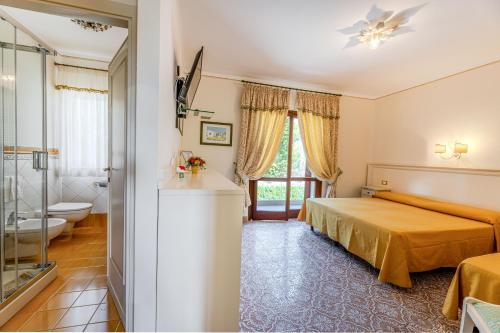 a hotel room with a bed and a bathroom at Villa Capitorsola in Capoliveri