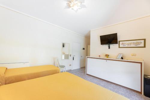 a small room with two beds and a flat screen tv at Villa Capitorsola in Capoliveri