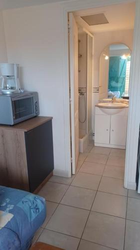 une cuisine avec un four micro-ondes au-dessus d'un comptoir dans l'établissement Le Clos Do Ré, à Sainte-Marie de Ré