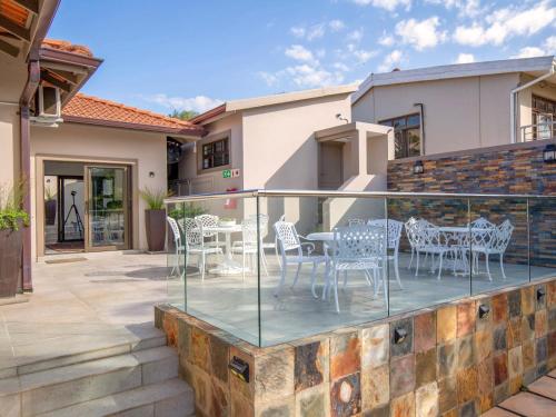 a patio with a table and chairs on a balcony at 31 on Windsor Guest House in Durban