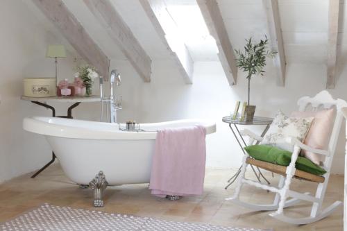 a bathroom with a white bath tub and a chair at Villa Station by Cassai in Ses Salines