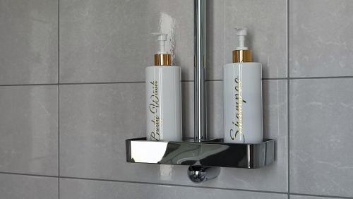 a wall mounted soap dispenser with two white bottles at Apartment Villa Elsa in Portorož
