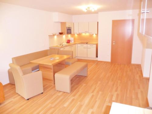 a room with a kitchen with a table and a desk at Ferienhäuser Tröster in Bad Kleinkirchheim