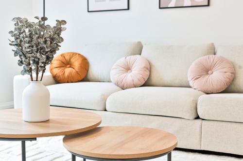 a living room with a couch with pink pillows at Amazing 3 Bed Apartment Great Portland Street in London