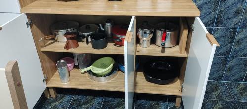 a wooden cupboard with coffee makers and other items at Casa Temporada em Embu das Artes in Embu