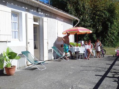 un groupe d'enfants assis à une table sous un parapluie dans l'établissement Domaine de Laroque Lou Maïsouet, à Casteljaloux