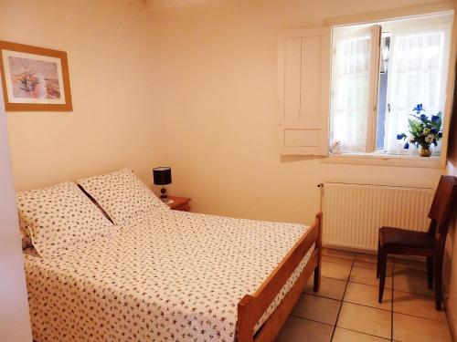 une chambre avec un lit et une fenêtre dans l'établissement Domaine de Laroque Lou Maïsouet, à Casteljaloux