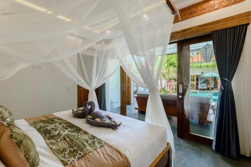 Un dormitorio con una cama con cortinas y vista a una piscina. en Villa Dewi Parwati - Private Villa with Pool - North Bali - private cook, en Tegallengah