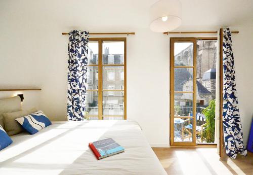 a bedroom with a bed with a book on it at Ti Melen in Morlaix