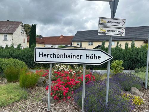 a sign in front of a garden with flowers at Wohnung im Herzen des Vogelsbergs direkt an der Herchenhainer Höhe in Grebenhain