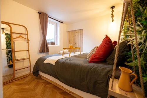 une chambre avec un lit avec des oreillers rouges dans l'établissement Eden Urbain hypercentre Rouen, à Rouen