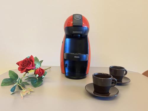 a coffee maker and two cups on a table at Estudio de diseño con piscina by Gloove in Murcia